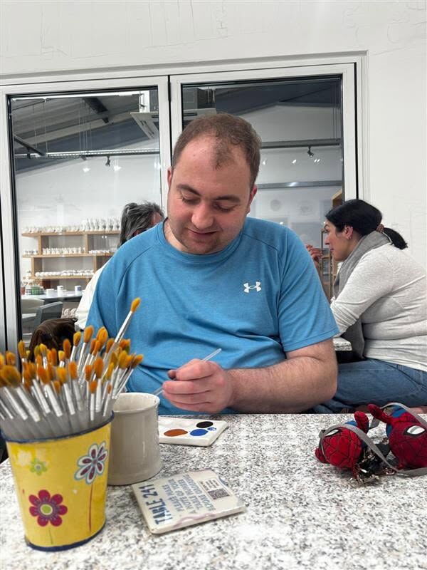 Concentrating on painting a pottery piece